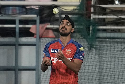 Punjab Kings' Arshdeep Singh tosses the ball after takes the catch to dismiss Gujarat Titans' Washington Sundar during the Indian Premier League cricket match between Gujarat Titans and Punjab Kings in New Chandigarh.