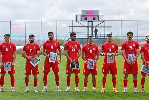 Iran's players pose for photographers holding pictures of children allegedly killed in a U.S. strike in Iran before a friendly soccer match between Iran and Costa Rica, in Antalya, southern Turkey.