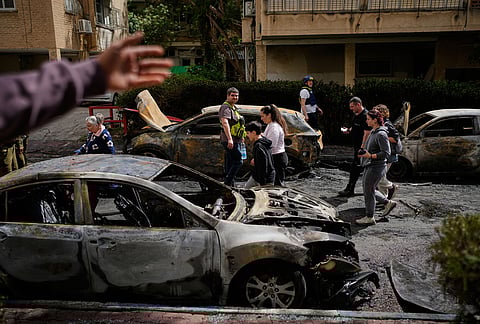 Residents and Israeli security forces inspect a site struck by an Iranian missile in Petah Tikva, Israel.
