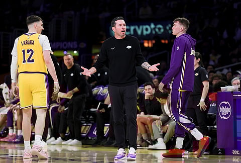 Los Angeles Lakers head coach JJ Redick, center, reacts near forwards Jake LaRavia, left, and Dalton Knecht during the second half of an NBA basketball game in Los Angeles. 