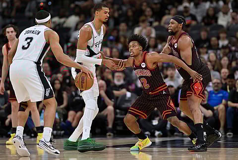 Chicago Bulls guard Collin Sexton (2) tangles with San Antonio Spurs center Victor Wembanyama, center left, during the second half of an NBA basketball game, in San Antonio. 