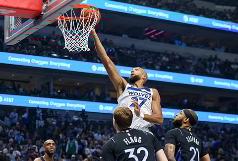 Minnesota Timberwolves center Rudy Gobert (27) scores past Dallas Mavericks forwards Daniel Gafford (21) and Cooper Flagg (32) in the first half of an NBA basketball game in Dallas.
