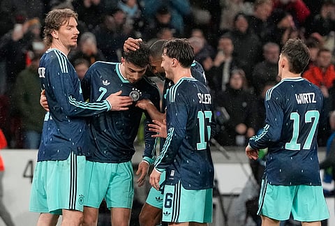 Kai Havertz of Germany is celebrated by teammates after he scored the opening goal from the penalty spot during an international friendly soccer match between Germany and Ghana in Stuttgart, Germany.