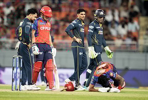 Punjab Kings' captain Shreyas Iyer, right, rolls on the ground in pain after getting hit by a shot from batting partner Cooper Connolly, second left, during the Indian Premier League cricket match between Gujarat Titans and Punjab Kings in New Chandigarh.