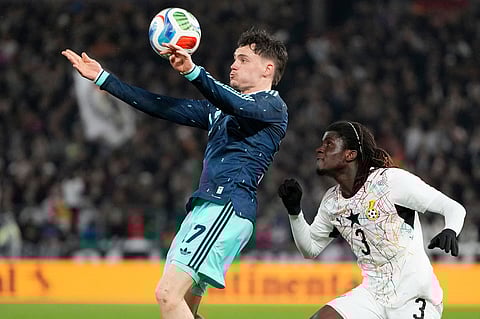 Florian Wirtz of Germany and Caleb Yirenkyi of Ghana challenge for the ball during an international friendly soccer match between Germany and Ghana in Stuttgart, Germany.
