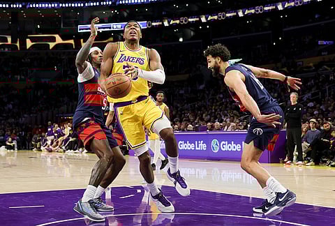 Los Angeles Lakers forward Rui Hachimura, center, drives against Washington Wizards guard Jamir Watkins, left, and forward Anthony Gill during the second half of an NBA basketball game in Los Angeles.