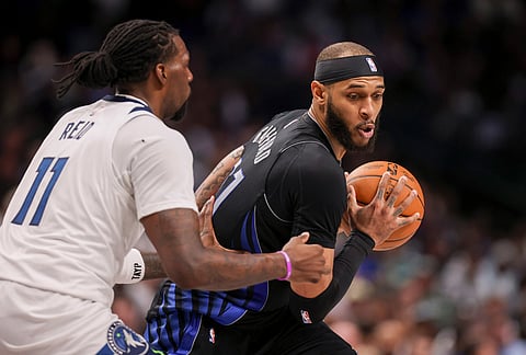 Dallas Mavericks forward Daniel Gafford (21) is guarded by Minnesota Timberwolves center Naz Reid (11) in the second half of an NBA basketball game in Dallas.