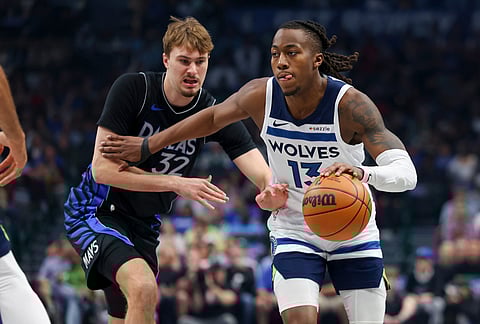 Minnesota Timberwolves guard Ayo Dosunmu (13) drives past Dallas Mavericks forward Cooper Flagg (32) in the first half of an NBA basketball game in Dallas.