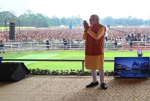 Prime Minister Narendra Modi greets a gathering during a public meeting, in Gogamukh, Assam. 