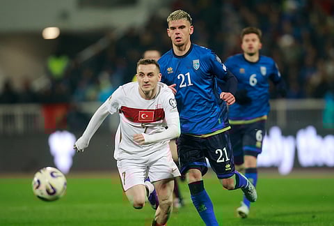 Turkey's Kerem Akturkoglu and Kosovo's Albian Hajdari challenge for the ball during the World Cup qualifying playoff final soccer match between Kosovo and Turkey in Pristina, Kosovo.