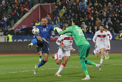 Kosovo's Vedat Muriqi and Turkey's goalkeeper Ugurcan Cakir challenge for the ball during the World Cup qualifying playoff final soccer match between Kosovo and Turkey in Pristina, Kosovo.