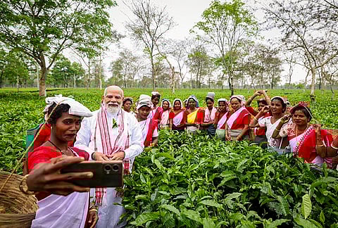 Prime Minister Narendra Modi poses for photographs with women workers at a tea garden, in Dibrugarh, Assam. 