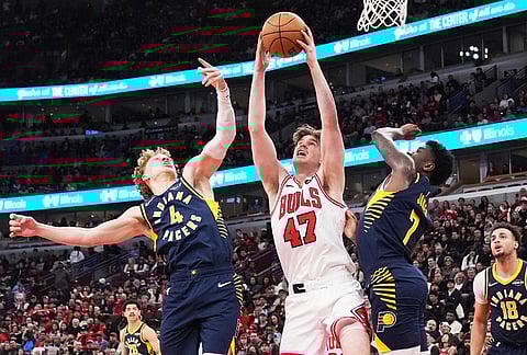 Chicago Bulls center Lachlan Olbrich (47) rebounds a ball against Indiana Pacers guard Taelon Peter, left, and guard Kam Jones during the first half of an NBA basketball game in Chicago.
