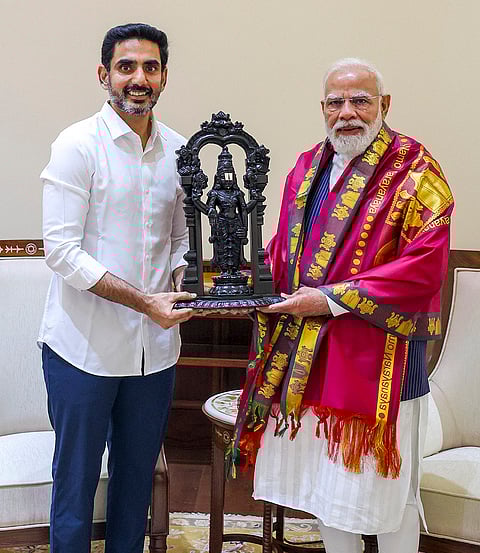 Prime Minister Narendra Modi, right, being felicitated by Andhra Pradesh HRD Minister Nara Lokesh during a meeting. 