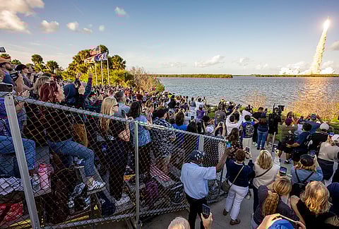 People gather as NASA's Space Launch System (SLS) rocket carrying the Orion spacecraft lifts off on the Artemis II mission from the Kennedy Space Center, in Cape Canaveral, Florida. 