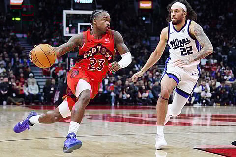 Toronto Raptors' Jamal Shead (23) drives past Sacramento Kings' Devin Carter (22) during the first half of an NBA basketball game in Toronto.