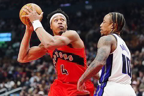 Toronto Raptors' Scottie Barnes (4) protects the ball from Sacramento Kings' DeMar DeRozan (10) during first half of an NBA basketball game in Toronto.