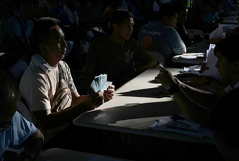 A jeepney driver poses after receiving cash assistance from the government to help in their livelihood as oil prices continue to rise, Wednesday, March 25, 2026, in Quezon city, Philippines. 