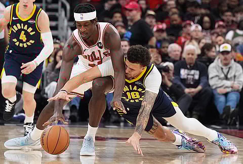 Chicago Bulls forward Leonard Miller, left, and Indiana Pacers forward Jalen Slawson battle for a loose ball during the second half of an NBA basketball game in Chicago.