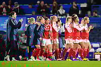 | Photo: John Walton/PA via AP : Arsenal players applaud fans after winning the Women's Champions League quarterfinal second leg soccer match against Chelsea in London.