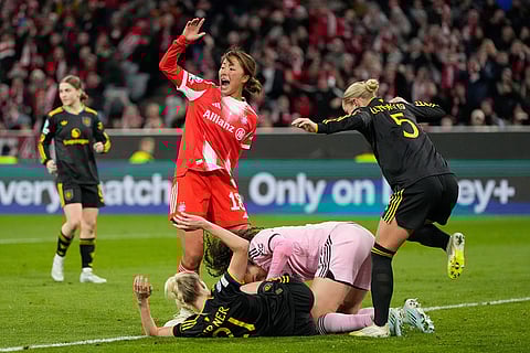 Bayern's Momoko Tanikawa reacts as Manchester United's Millie Turner collides with Bayern's goalkeeper Ena Mahmutovic during the Women's Champions League quarterfinal second leg soccer match between Bayern Munich and Manchester United in Munich, Germany.