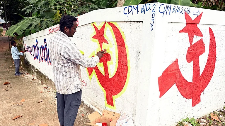Artists paint the LDF symbol on a wall as part of preparations for the upcoming Kerala local body elections, in Thiruvananthapuram. - | Photo: PTI| Representative Image