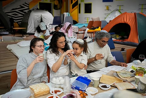 Families celebrate the Passover Eve dinner at a festive table in an underground shelter, in Ramat Gan, Israel.