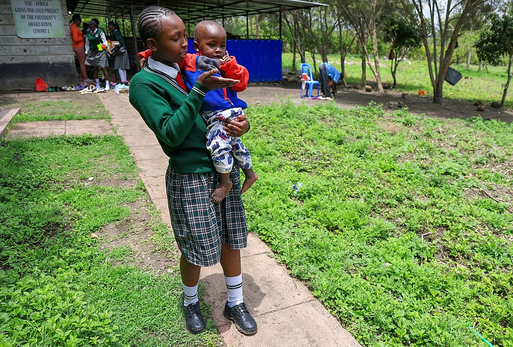 Valarie Wairimu, 19, interacts with her son, Kayden Darmain during breaktime at Greenland Girls School in Kiserian, Kajiado, Kenya.  - | Photo: AP/Andrew Kasuku