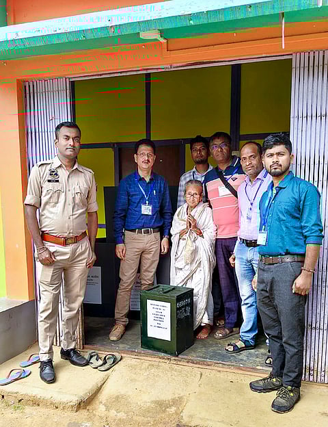 Polling officials with an elderly woman, pose for a picture for the optional home voting facility, Assam. 