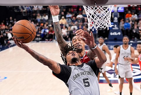 San Antonio Spurs guard Stephon Castle, below, shoots as Los Angeles Clippers forward John Collins defends during the second half of an NBA basketball game in Inglewood, California.