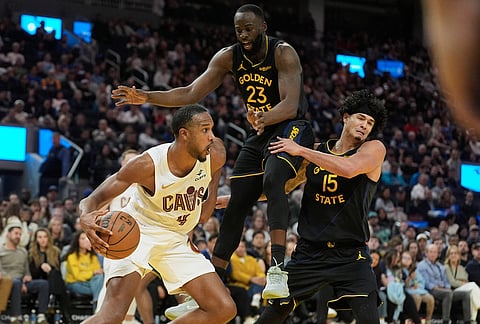 Cleveland Cavaliers center Evan Mobley (4) drives to the basket against Golden State Warriors forward Draymond Green (23) and forward Gui Santos (15) during the second half of an NBA basketball game in San Francisco.