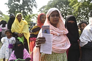 IMAGO / ZUMA Press Wire : Morigaon, Assam, India: Women voters show their ID cards as they wait to cast their votes