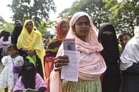  IMAGO / ZUMA Press Wire : Morigaon, Assam, India: Women voters show their ID cards as they wait to cast their votes