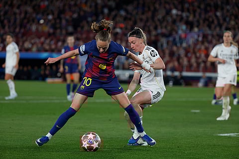 Barcelona's Graham Hansen, challenges for the ball with Real Madrid's Eva Navarro during a Champions League quarterfinal soccer match between Barcelona and Real Madrid, in Barcelona, Spain.