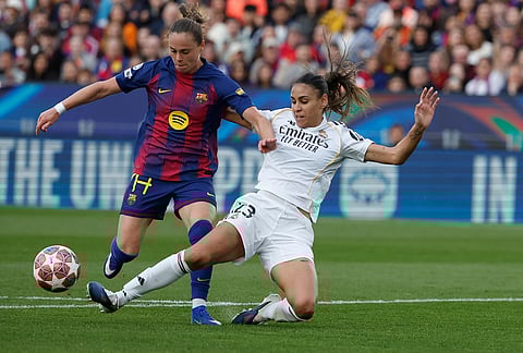 Barcelona's Ewa Pajor, challenges for the ball with Real Madrid's Maelle Lakrar during a Champions League quarterfinal soccer match between Barcelona and Real Madrid, in Barcelona, Spain.
