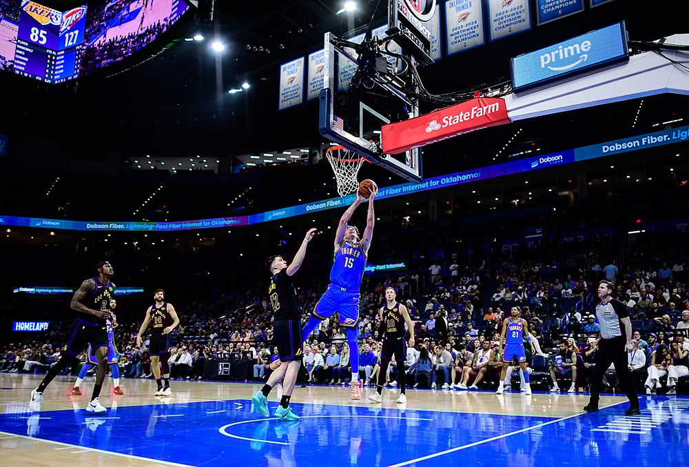 Oklahoma City Thunder center Branden Carlson (15) shoots against Los Angeles Lakers forward Jake LaRavia (12) during the second half of an NBA basketball game in Oklahoma City.  - | Photo: AP/Gerald Leong