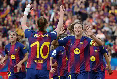 Barcelona's Graham Hansen celebrates with her teammates after scoring her side's second goal during a Champions League quarterfinal soccer match between Barcelona and Real Madrid, in Barcelona, Spain.