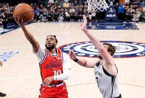 Los Angeles Clippers guard Darius Garland, left, shoots as San Antonio Spurs center Luke Kornet defends during the first half of an NBA basketball game in Inglewood, California. 