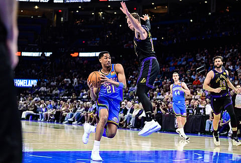 Oklahoma City Thunder guard Aaron Wiggins (21) drives against Los Angeles Lakers guard Luke Kennard (10) during the second half of an NBA basketball game in Oklahoma City.