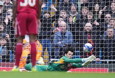 Manchester City's goalkeeper James Trafford saves a penalty kick during the FA Cup quarter-final soccer match between Manchester City and Liverpool in Manchester, England.