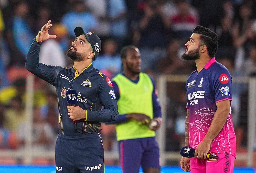 Gujarat Titans' captain Rashid Khan, left, flips the coin as Rajasthan Royals' captain Riyan Parag takes the call during the toss before an Indian Premier League (IPL) 2026 T20 cricket match between Gujarat Titans and Rajasthan Royals, in Ahmedabad, Gujarat. - | Photo: PTI/Kamal Kishore