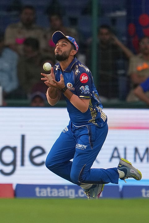 Mumbai Indians' Mayank Markande takes the catch to dismiss Delhi Capitals' Pathum Nissanka during the Indian Premier League cricket match between Delhi Capitals and Mumbai Indians in New Delhi.