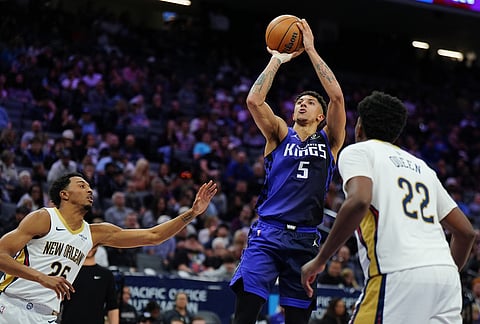 Sacramento Kings guard Nique Clifford (5) shoots the ball over New Orleans Pelicans forward Trey Murphy III, left, and center Derik Queen (22) during the second half of an NBA basketball game in Sacramento, California. 