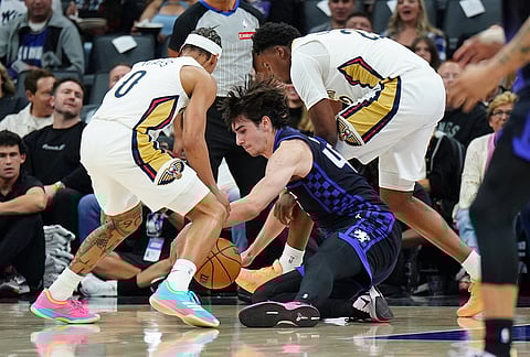 Sacramento Kings center Maxime Raynaud, center goes for the ball against New Orleans Pelicans guard Jeremiah Fears, left, and center Derik Queen, right, during the first half of an NBA basketball game in Sacramento, California. 