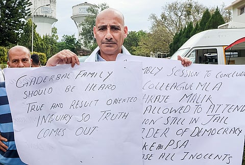 MLA Irfan Hafiz Lone holds placards demanding a probe into the alleged fake encounter in Ganderbal during the budget session of Jammu and Kashmir Assembly, in Jammu.