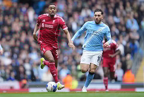 Manchester City's Rayan Cherki runs after Liverpool's Ryan Gravenberch during the FA Cup quarter-final soccer match between Manchester City and Liverpool in Manchester, England.
