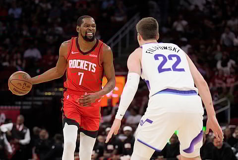 Houston Rockets forward Kevin Durant (7) controls the ball against Utah Jazz forward Kyle Filipowski (22) during the first half of an NBA basketball game, in Houston.