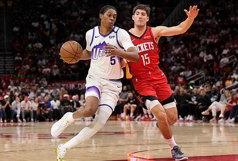 Utah Jazz forward Cody Williams (5) controls the ball against Houston Rockets guard Reed Sheppard (15) during the second half of an NBA basketball game, in Houston.