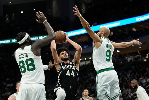 Milwaukee Bucks' Andre Jackson Jr. (44) drives to the basket between Boston Celtics' Neemias Queta (88) and Derrick White (9) during the first half of an NBA basketball game in Milwaukee.
