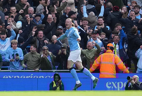 Manchester City's Erling Haaland celebrates after scoring during the FA Cup quarter-final soccer match between Manchester City and Liverpool in Manchester, England.